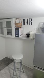 eine weiße Theke mit einem Stuhl und einem Schild mit der Bar in der Unterkunft Sweet Home by Schonnebeck in Essen