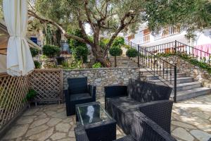 a patio with chairs and an umbrella and stairs at Villa Nina Adult only in Skiathos