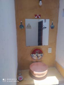 baño con aseo rosa y espejo en Cabaña El Paraíso en Tinogasta