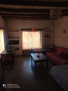 sala de estar con sofá y mesa en Cabaña El Paraíso en Tinogasta