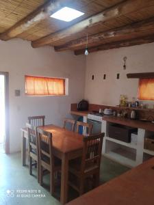 cocina con mesa de madera y sillas en una habitación en Cabaña El Paraíso en Tinogasta