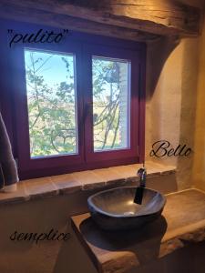 een badkamer met een wastafel voor een raam bij Casa della Casa in San Severino Marche