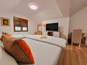 a bedroom with two beds and a flat screen tv at Buba Palace in Nikšić