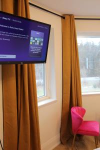 a tv in a room with a window and a red chair at 4 Guest Suite with Waterfront Views at Fancie's PEC in Belleville