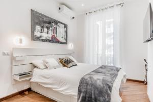 a white bedroom with a large white bed and a window at Sweethome Marconi in Rome