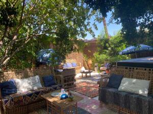 een patio met banken en een tafel in de tuin bij peace garden hostel & camp in Luxor