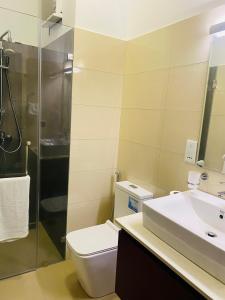 W łazience znajduje się toaleta, umywalka i prysznic. w obiekcie Ocean Breeze Hotel Residencies Luxury Studio Apartment - Negombo w Negombo