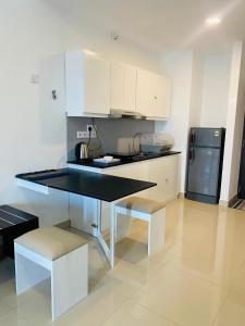 a kitchen with white cabinets and a black counter top at Ocean Breeze Hotel Residencies Luxury Studio Apartment - Negombo in Negombo