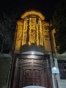 un edificio con luces en la parte superior de una puerta de madera en Luxury Guesthouse, en Samarkand