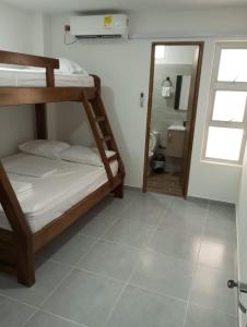1 Schlafzimmer mit 2 Etagenbetten und einem Badezimmer in der Unterkunft Apartamento Villa Mary-Coveñas in Coveñas