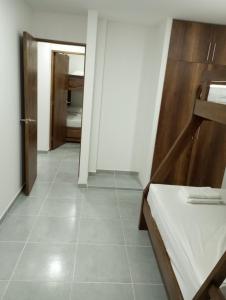 Zimmer mit einem Bett und einem Flur mit einer Tür in der Unterkunft Apartamento Villa Mary-Coveñas in Coveñas