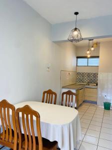 een keuken met een tafel en stoelen in een kamer bij Selesa Hillhomes Cosy House in Bentong