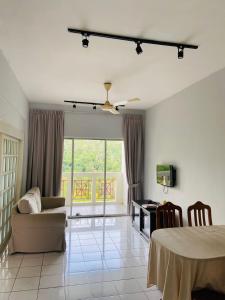 een woonkamer met een bank en een tafel bij Selesa Hillhomes Cosy House in Bentong