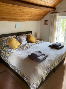 a bedroom with a large bed with towels on it at The Drumlins Cottage in Ulverston