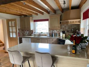 a kitchen with a table with chairs and a counter top at The Drumlins Cottage in Ulverston