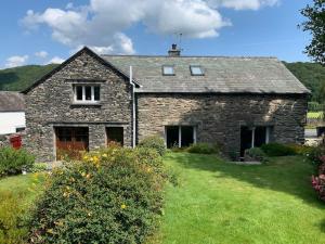 an old stone house with a green yard at The Drumlins Cottage in Ulverston