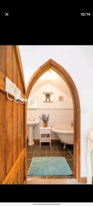La salle de bains est pourvue d'une voûte, d'une baignoire et d'un lavabo. dans l'établissement The Dovecote, à Launceston