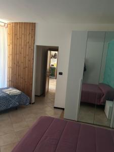 アンテイ・サンタンドレにあるAlbergo La Grollaのベッド1台、鏡、ドアが備わる客室です。