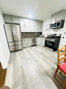 een keuken met witte kasten en roestvrijstalen apparatuur bij 3 Bedrooms House Nassau County in Hempstead