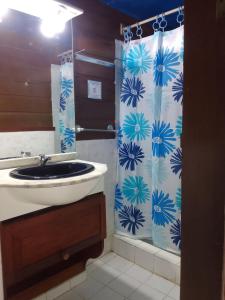 a bathroom with a sink and a shower curtain at Casa elba sobre el mar in Bocas del Toro