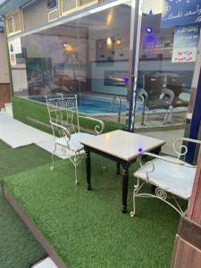 un tavolo e due sedie seduti accanto alla piscina di Roof chalets Roof chalets a Abha