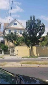 a house on the side of a street with a tree at *PRIVATE* Studio 5 minutes from LGA/ US Open in East Elmhurst