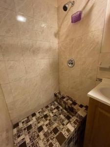 uma casa de banho com um chuveiro e piso em azulejo em *PRIVATE* Studio 5 minutes from LGA/ US Open em East Elmhurst