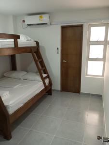 1 Schlafzimmer mit 2 Etagenbetten und einer Tür in der Unterkunft Apartamento Villa Mary-Coveñas in Coveñas
