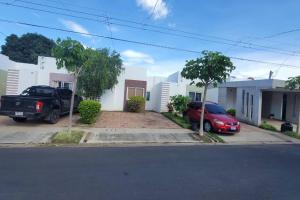 ein Haus mit zwei Autos, die in einer Einfahrt geparkt sind in der Unterkunft Vivienda familiar in San Miguel