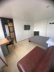 波哥大的住宿－Destino Nómada Calle 11 n 1-38，一间卧室配有一张床、一张桌子和一张沙发