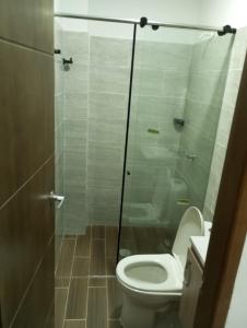 a bathroom with a toilet and a glass shower at Apartamento Villa Mary-Coveñas in Coveñas