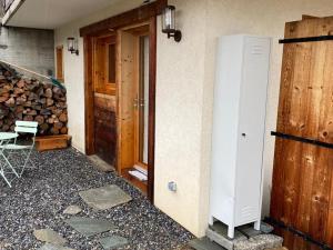 une porte menant à une maison dotée d'un tas de bois de feu dans l'établissement Renovated flat facing Mont Blanc, à Combloux