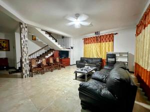 a living room with a leather couch and a table at Naturus Villa Thalpitiya in Panadura