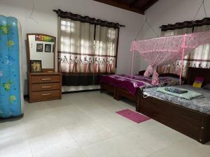 a bedroom with two beds and a mirror at Naturus Villa Thalpitiya in Panadura