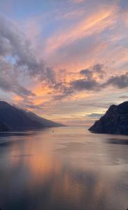a view of a large body of water at sunset at Hotel Giardino Verdi in Riva del Garda