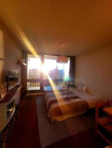 a bedroom with a bed in a room with a window at Studio 05 Saint Honoré 1500, Vue montagne et lac, 2 personnes, Série Anthracite Netflix in Saint-Honoré