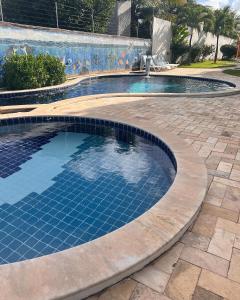 una piscina con azulejos azules en un patio en Apartamento Ocean View Tabatinga, en Nísia Floresta