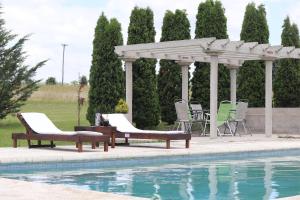 a gazebo and chairs next to a pool at Quinta Siete Soles in Tandil