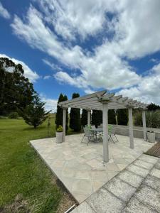 a pavilion with a table and chairs on a patio at Quinta Siete Soles in Tandil