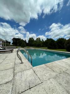 a swimming pool with a metal hand rail next to it at Quinta Siete Soles in Tandil