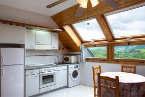 a kitchen with white appliances and a table and chairs at Apartamento Pico Aspe in Jaca