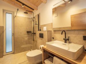 ein Bad mit einem Waschbecken, einem WC und einer Dusche in der Unterkunft Haus Becken in Sankt Jakob in Defereggen