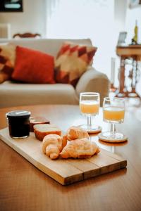 uma mesa com dois copos de sumo de laranja e pastelaria em ΕΥΕΛΗ em Édessa