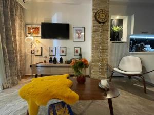 a living room with a yellow blanket on a table at Avant-Garde Studio in Athens