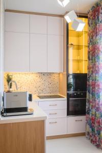eine Küche mit weißen Schränken und einem Drucker auf der Theke in der Unterkunft Mountain view apartment in Almaty