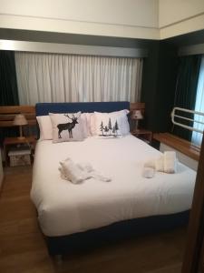 sypialnia z łóżkiem z poduszkami jelenia i świątecznymi w obiekcie La Casa Shabby w mieście Marilleva