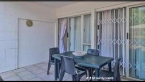 a dining room with a black table and chairs at Toti Cabana 58 in Amanzimtoti