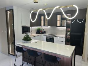 a kitchen with a white counter and a chandelier at Usmans 4BDRM APARTMENT SEA VIEW Rimal in Dubai