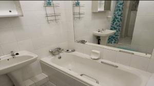 a white bathroom with a tub and a sink at Toti Cabana 58 in Amanzimtoti +25 photos