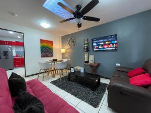 a living room with a couch and a ceiling fan at Elegante Casa de 4 Habitaciones a Solo 15 Minutos del Corazón de la Ciudad in San José